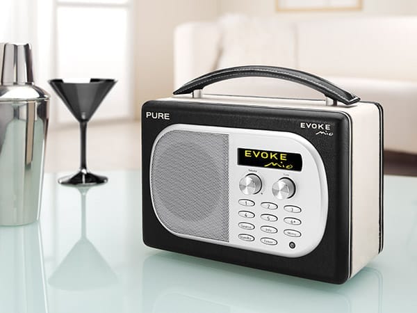 Přenosný digitální rádiový přijímač Pure Evoke Mio s koženou rukojetí a displejem, na skleněném stolku