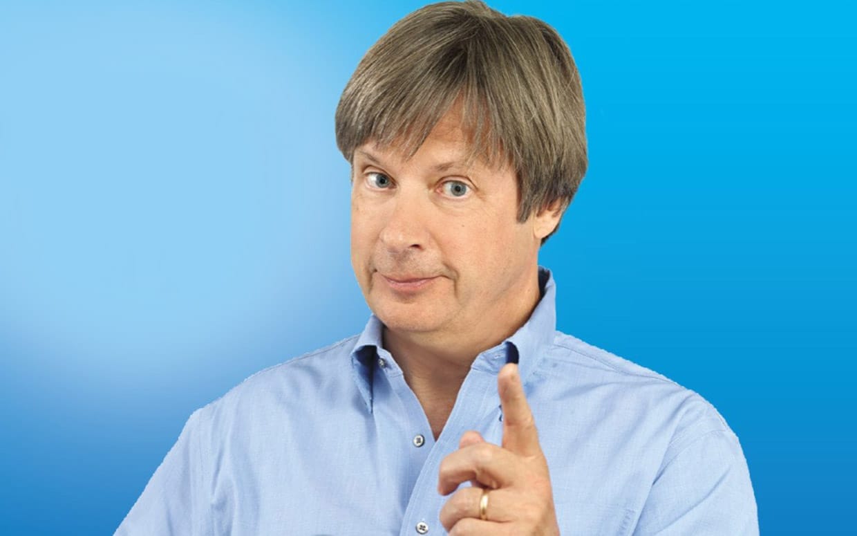 Dave Barry v modré košili se zdviženým ukazovákem na modrém pozadí