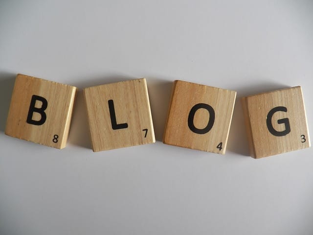 Čtyři dřevěné hrací kameny s písmeny skládají slovo BLOG