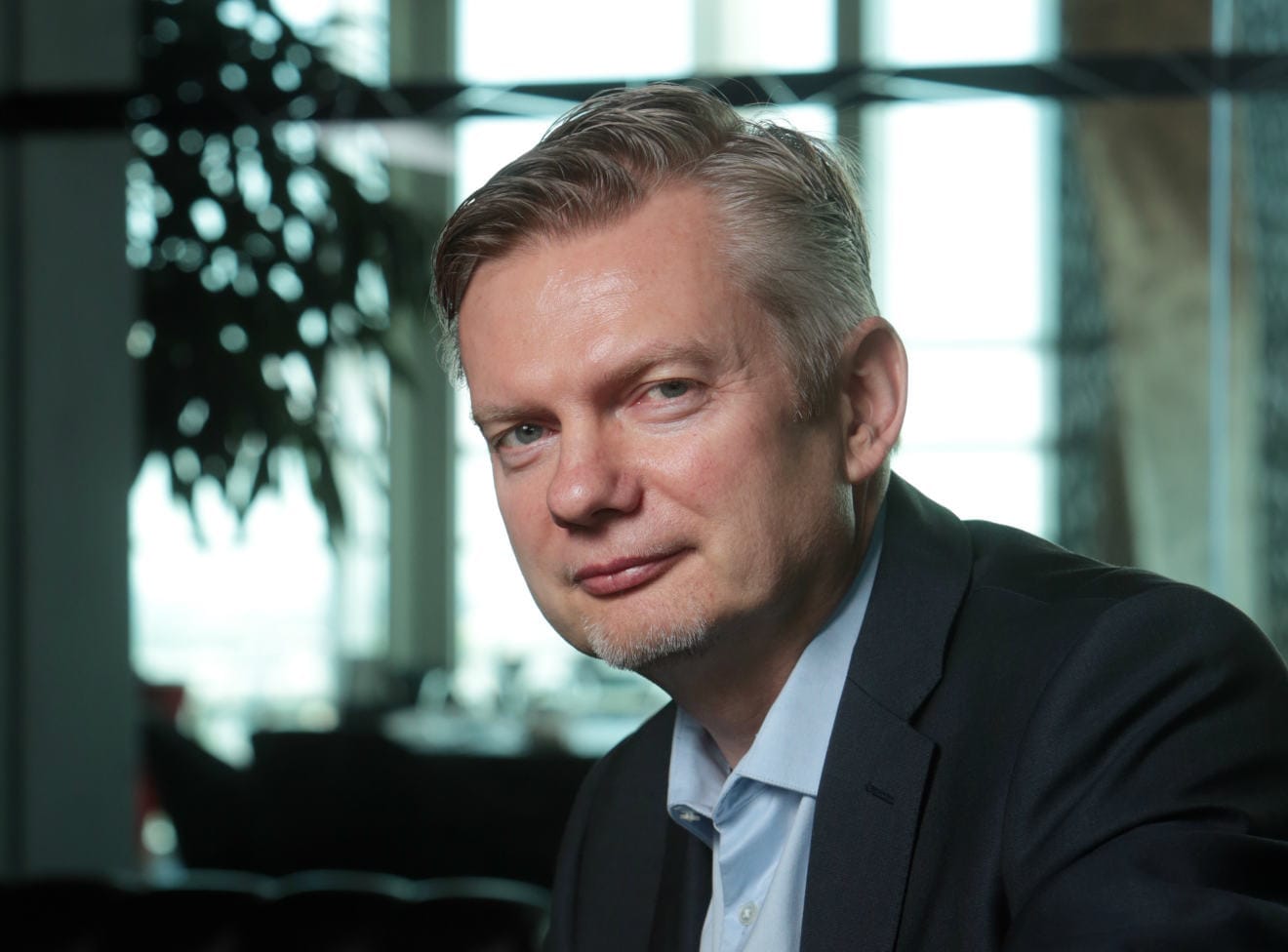 Tomáš Budník, generální ředitel O2, v tmavém saku a světlé košili u prosklené stěny