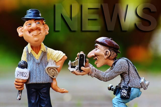Figurky karikovaného reportéra s mikrofonem s nápisem Press a fotografa s foťákem, v pozadí velký nápis NEWS
