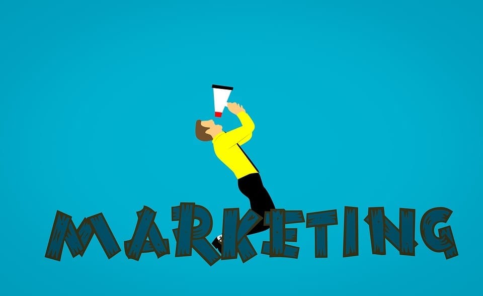 Kreslený muž ve žluté košili křičí do megafonu nad nápisem MARKETING