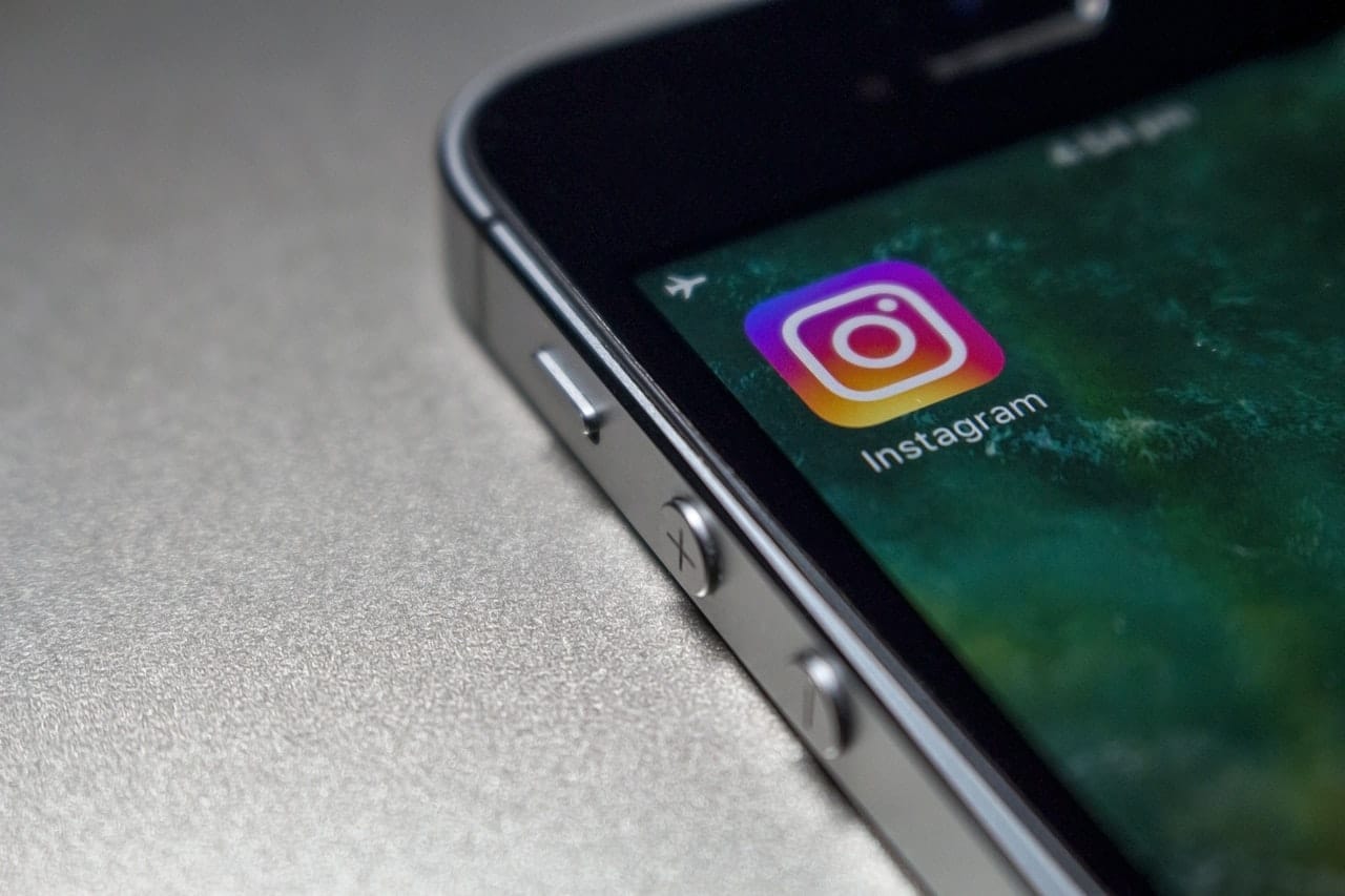Detail rohu mobilního telefonu s ikonou aplikace Instagram na displeji